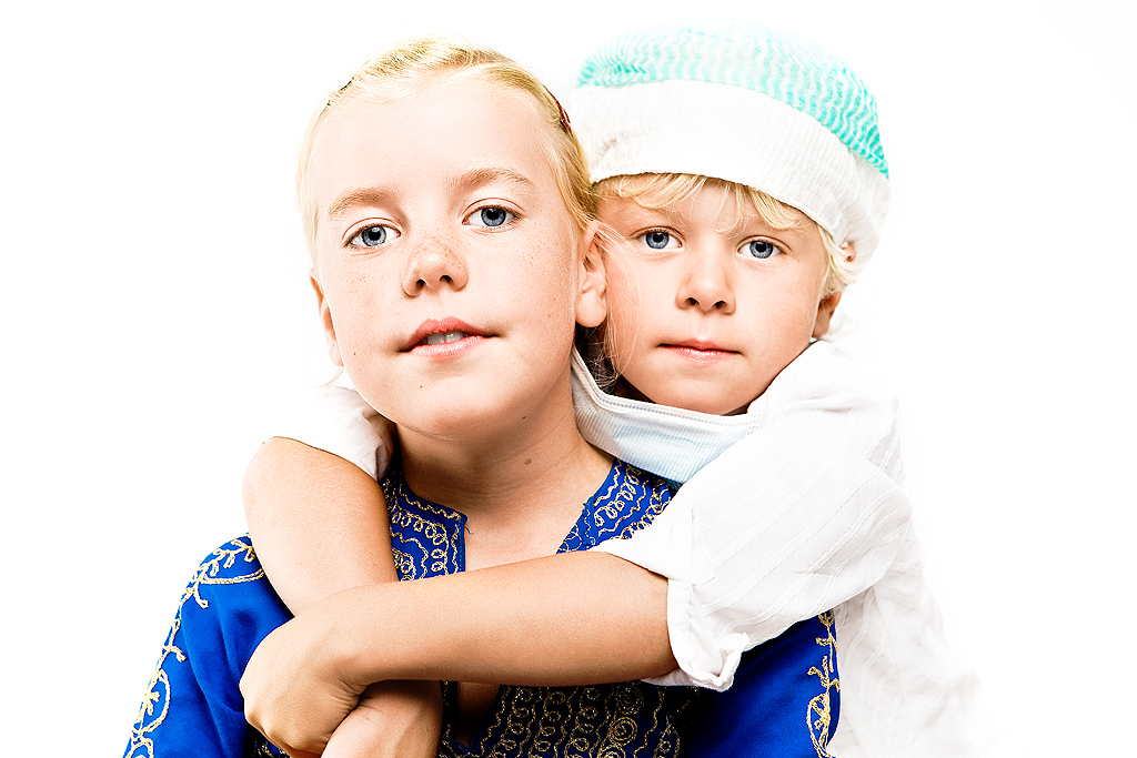 Pojke i operationsmössa står bakom flicka och kramar henne.