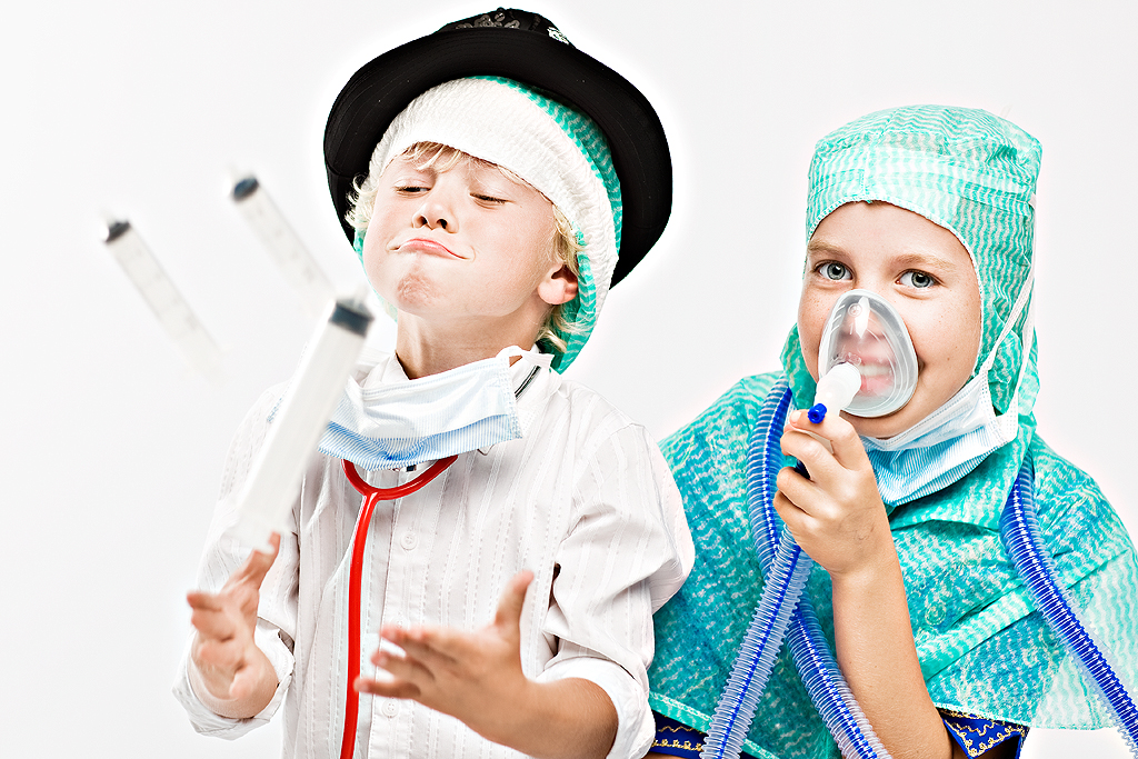 Pojke och flicka leker med sprutor och andningsmask.