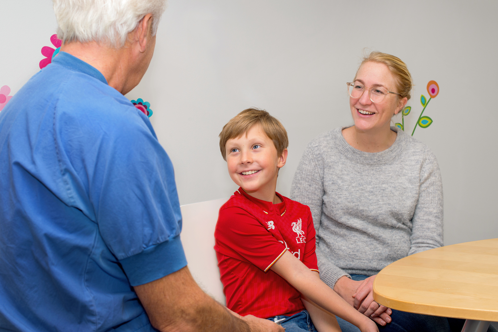 Pojke och mamma pratar med doktor.