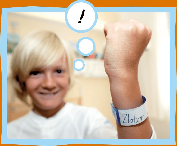 Lucas visar upp sitt sjukhusarmband som det står Zlatan på. 
